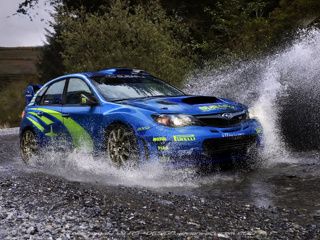 Modrá rally auto striekajúca vodu